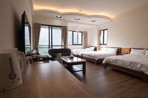 A hotel room with two beds, a desk with a kettle, a chair, and a TV. - Place of Heart (Lugu)