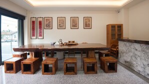 A spacious dining area with a large wooden table, six wooden stools, and a marble counter. - Place of Heart (Lugu)