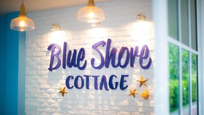 A wall with the text "Blue Shore Cottage" and decorative stars.
