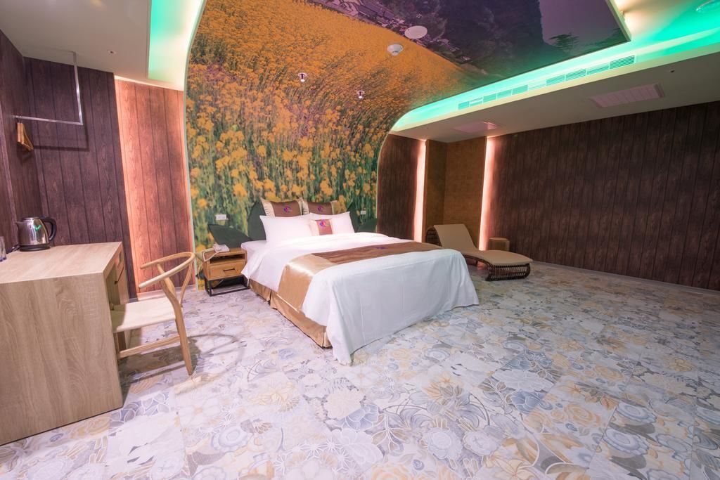 A bedroom with a bed, a desk, and a chair.