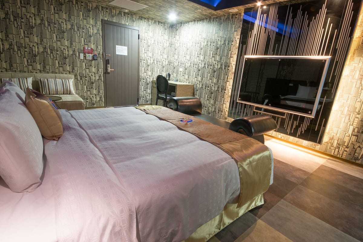 Een hotelkamer met een groot bed, een bureau en een televisie.