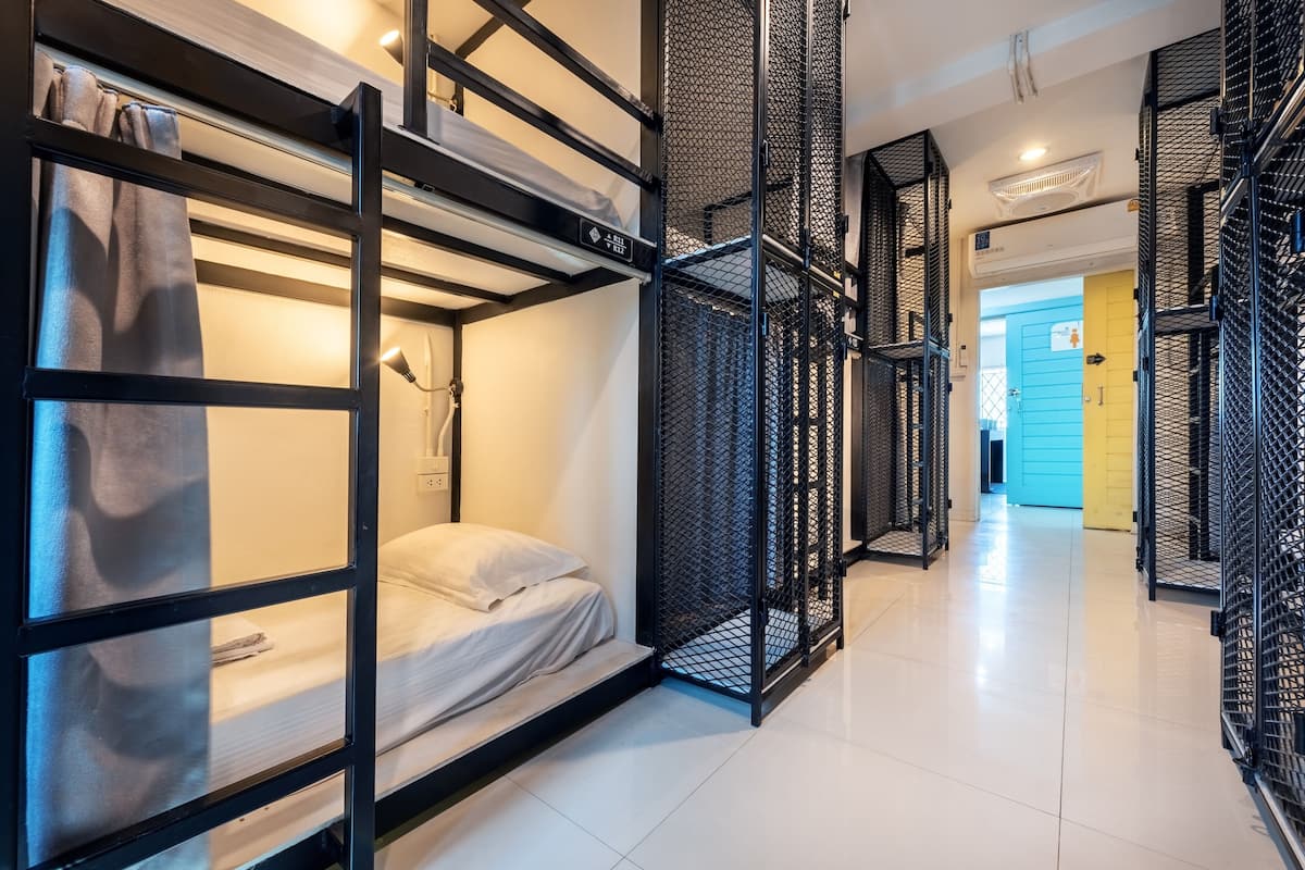 A modern hotel room with bunk beds, a desk, and a walk-in closet.
