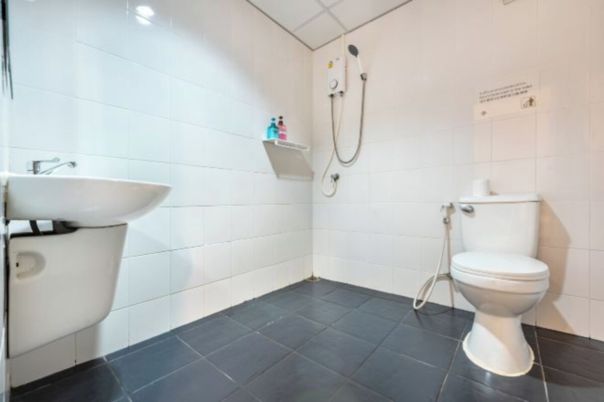 A modern bathroom with a white sink, toilet, and shower.