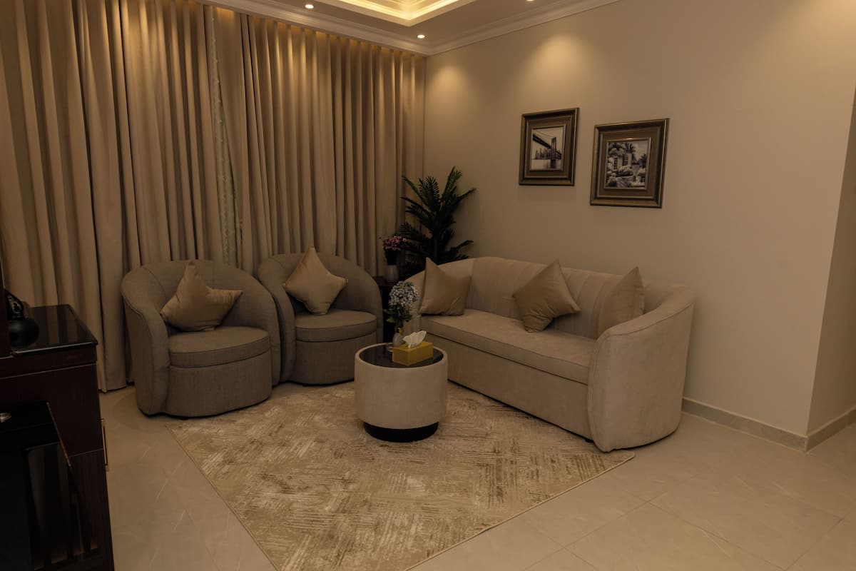 A living room with two sofas, a coffee table, and a TV stand.