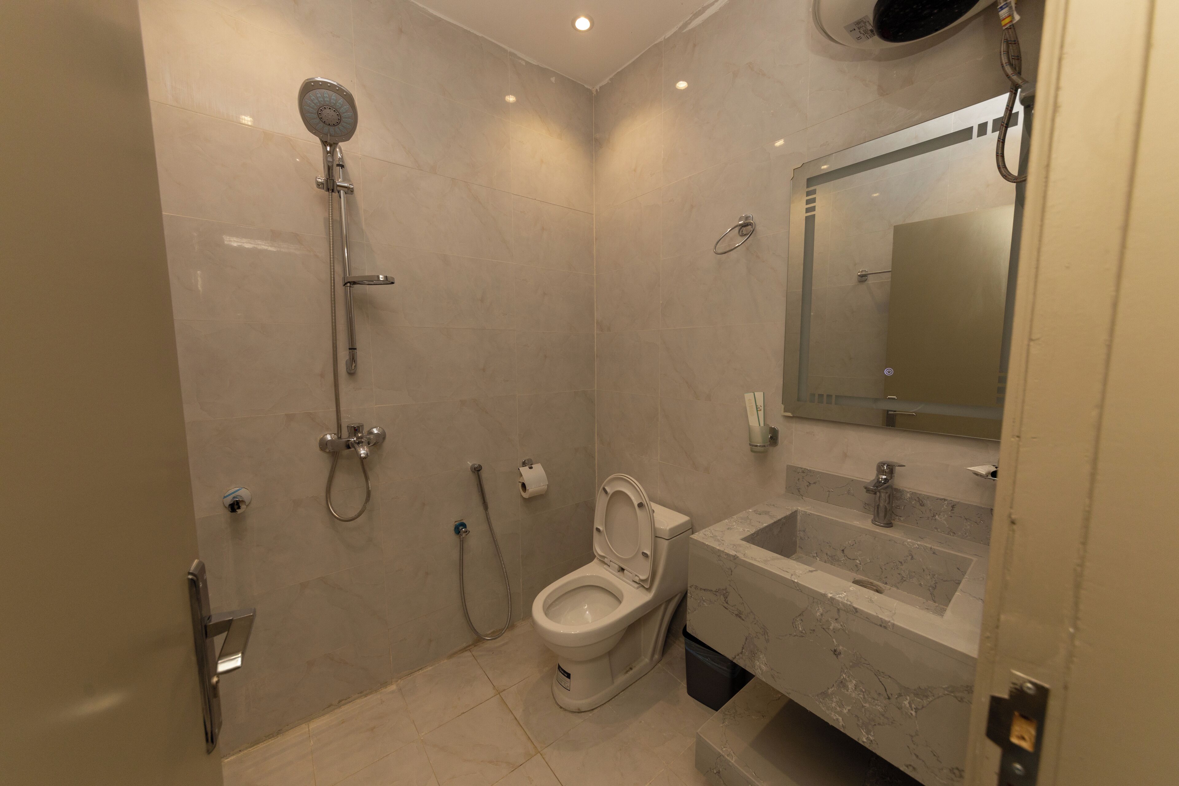 A modern bathroom with a toilet, shower, and sink.