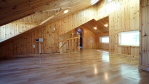 Un espacio amplio en el ático, con paredes de madera y techo inclinado.