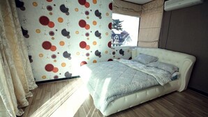 Un dormitorio con una cama, cortinas y una pared con estampado de lunares.