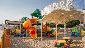 A playground with slides and climbing structures, a covered seating area, and a sign that reads "BABY PARK". - Hotel Confort (Cattolica)