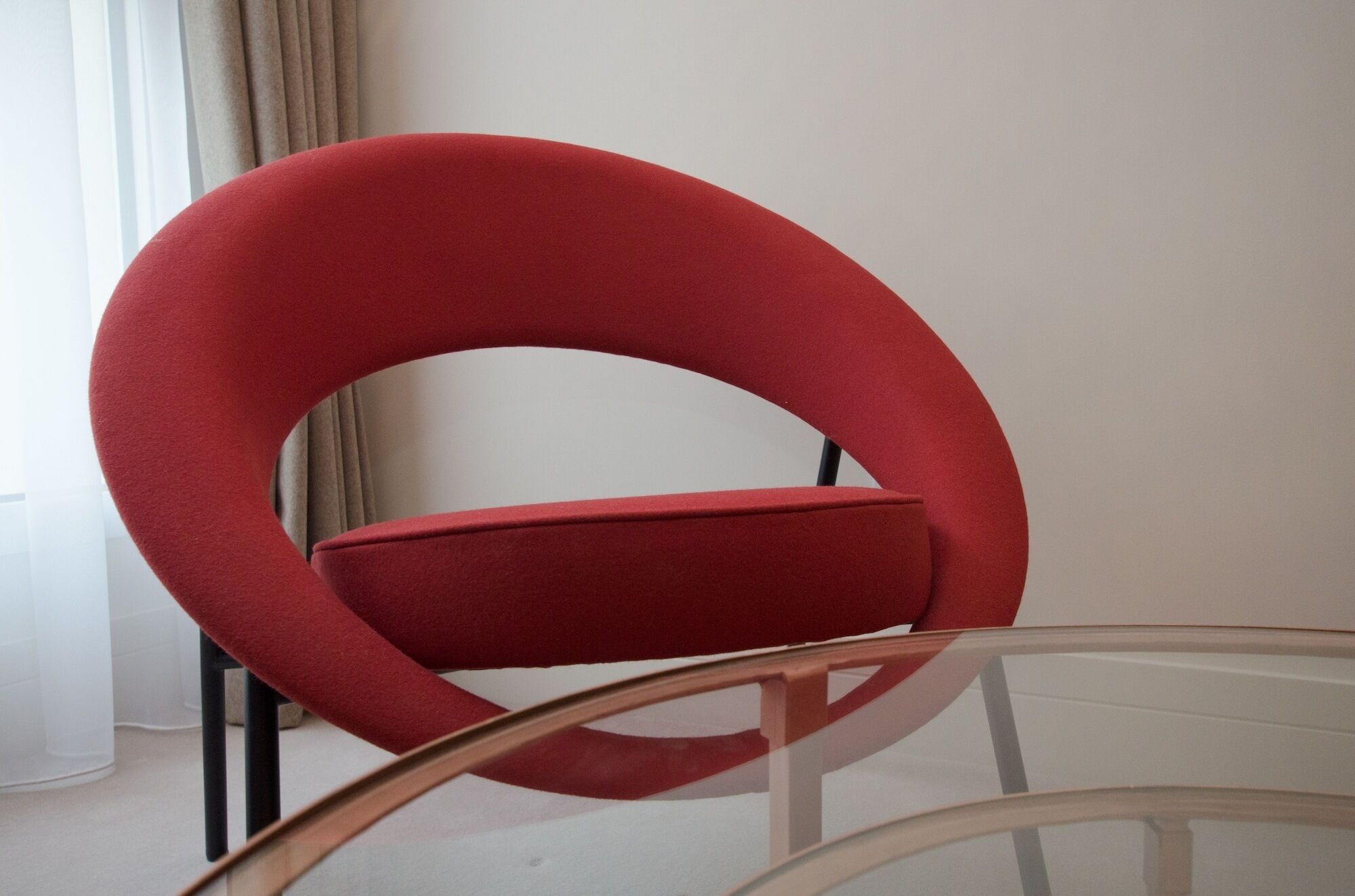 A red chair with a circular backrest and a cushioned seat.