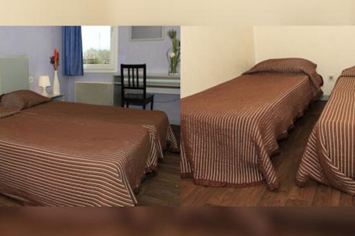A room with a bed, a chair, and a window.