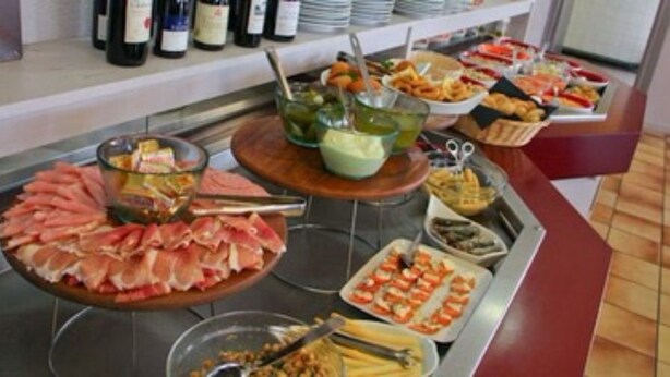 Un bufé con diversos alimentos y acompañamientos.