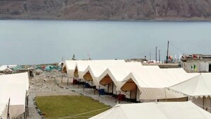 A row of white tents with a view of a lake and mountains in the background. - Wonderland Camps (Leh)