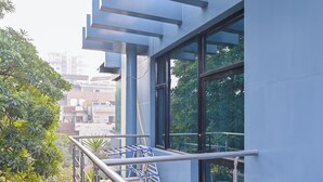 A modern building with large windows and a balcony with a metal railing. - Imperial Apartments Gurugram (Gurugram)