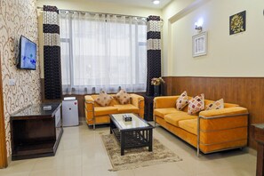 Garden Suite | Woonkamer | Een 36-inch flatscreentelevisie met satellietzenders en een televisie