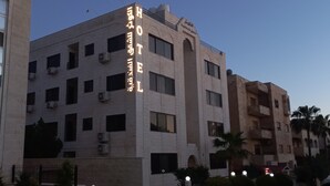 A multi-story building with a prominent sign in Arabic.