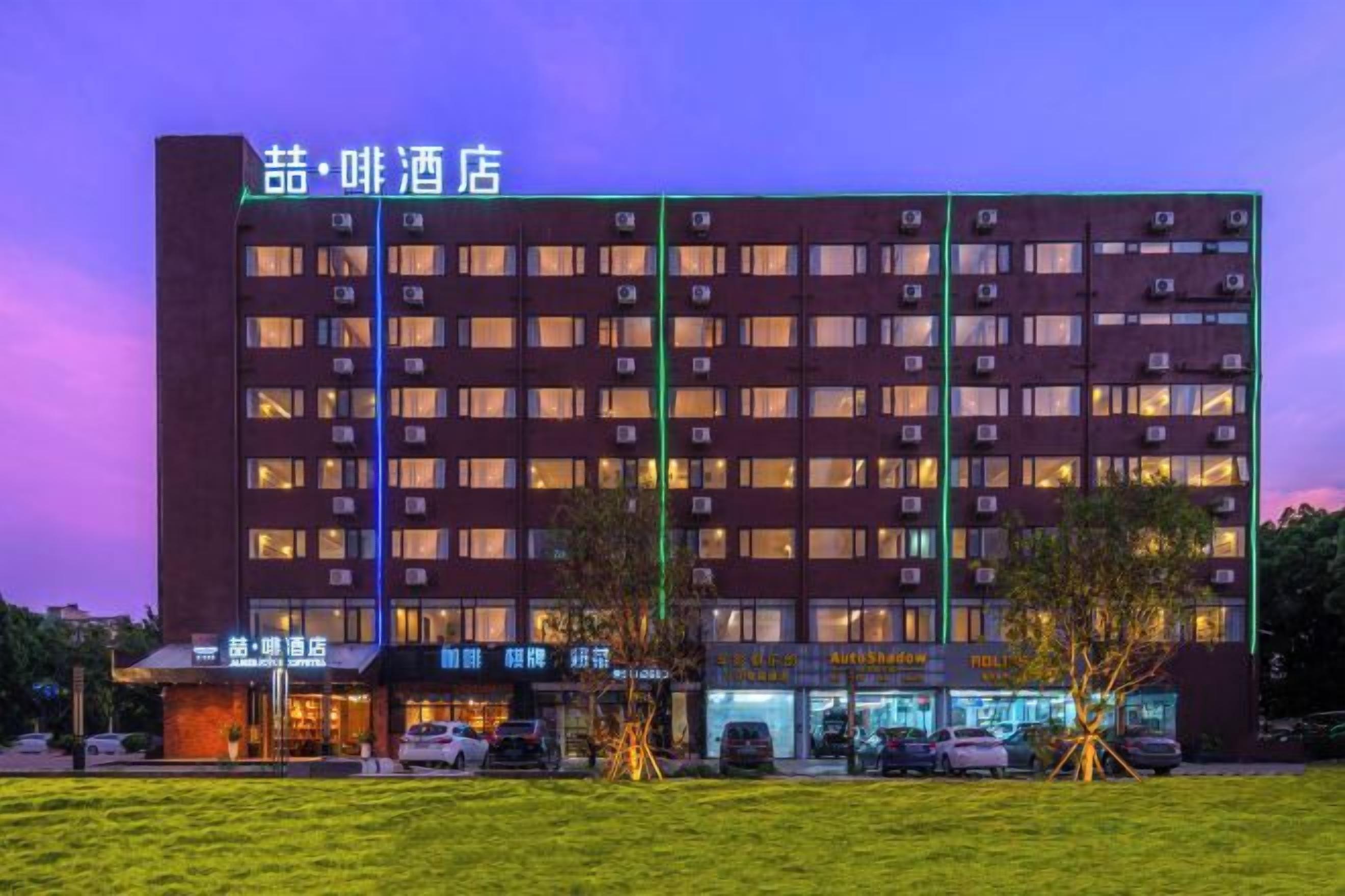 Un hotel de varios pisos con fachada plana, múltiples ventanas y un letrero que indica que es un hotel.