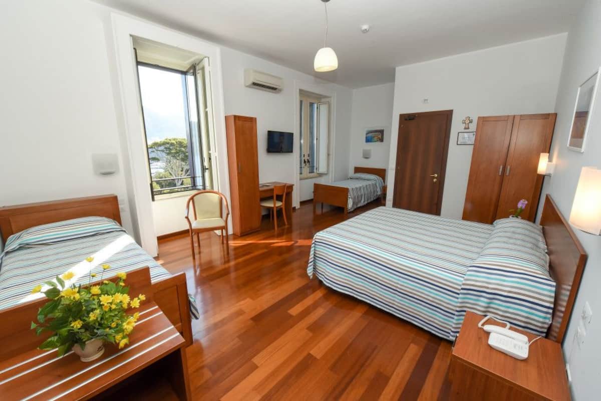 Eenvoudige vierpersoonskamer, meerdere bedden | Een kluis op de kamer, een bureau, gratis wifi, beddengoed