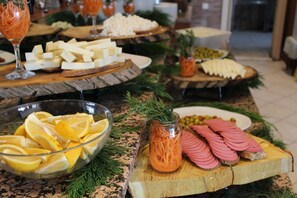 Un bufé con diversos alimentos, incluyendo queso, pan y fiambres.