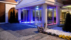 A hotel entrance with a glass facade, a stone pathway, and a small garden area with rocks and plants. - Doktorun Oteli Haymana (Haymana)