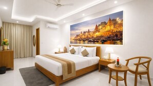 A hotel room with a large bed, bedside tables, a desk, a chair, a ceiling fan, and a large window with a view of a cityscape. - OPO Viva Palace (New Delhi)
