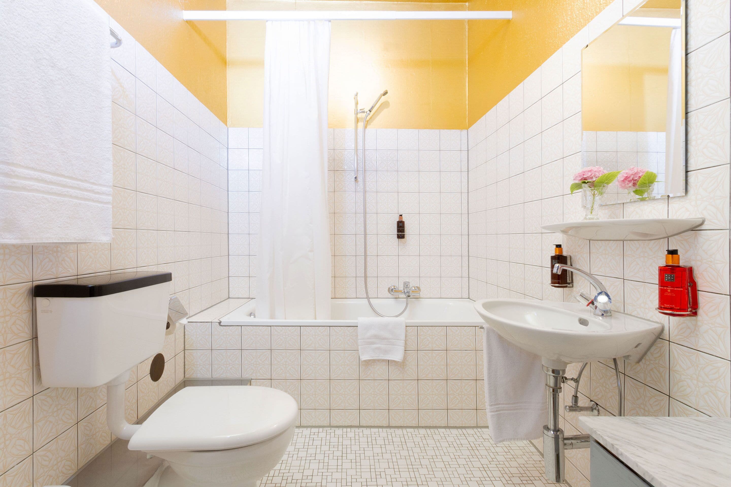 A bathroom with a toilet, sink, and shower.