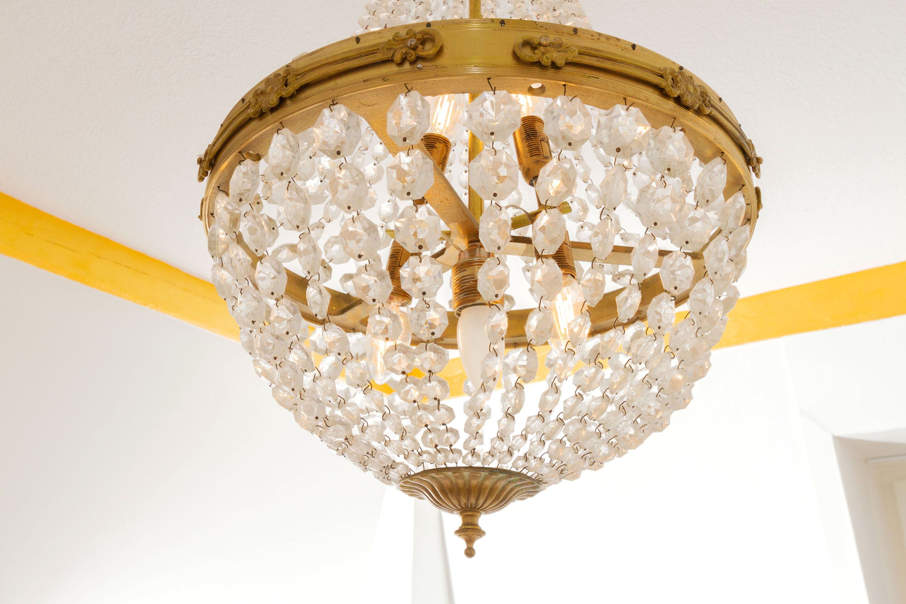 A chandelier with multiple crystal elements and a gold-colored frame.