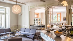 Una habitación luminosa y elegantemente amueblada, con zona de estar, bar y vistas al exterior.