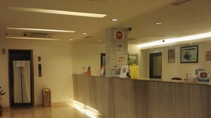 A hotel reception area with a polished tile floor, a reception desk, and a security camera on the ceiling. - Hotel Mercury (Kuala Lumpur)