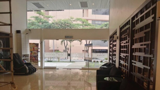A hotel lobby with a tiled floor, a reception desk, and a view of the outside. - Hotel Mercury (Kuala Lumpur)
