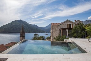 Una piscina al aire libre, sombrillas, tumbonas