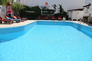 Utomhuspool, parasoller och solstolar