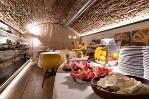 Un ristorante con soffitto in mattoni, tavoli bianchi e diversi piatti esposti sui tavoli.