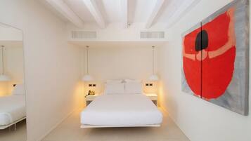 A modern bedroom with a central bed, bedside lamps, a large mirror, and a red abstract painting on the wall.