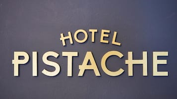 Un letrero con las palabras 'HOTEL PISTACHE' en letras de madera.