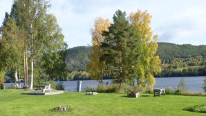 Un terrain de camping au bord du lac, équipé de tables de pique-nique et d’un petit abri.