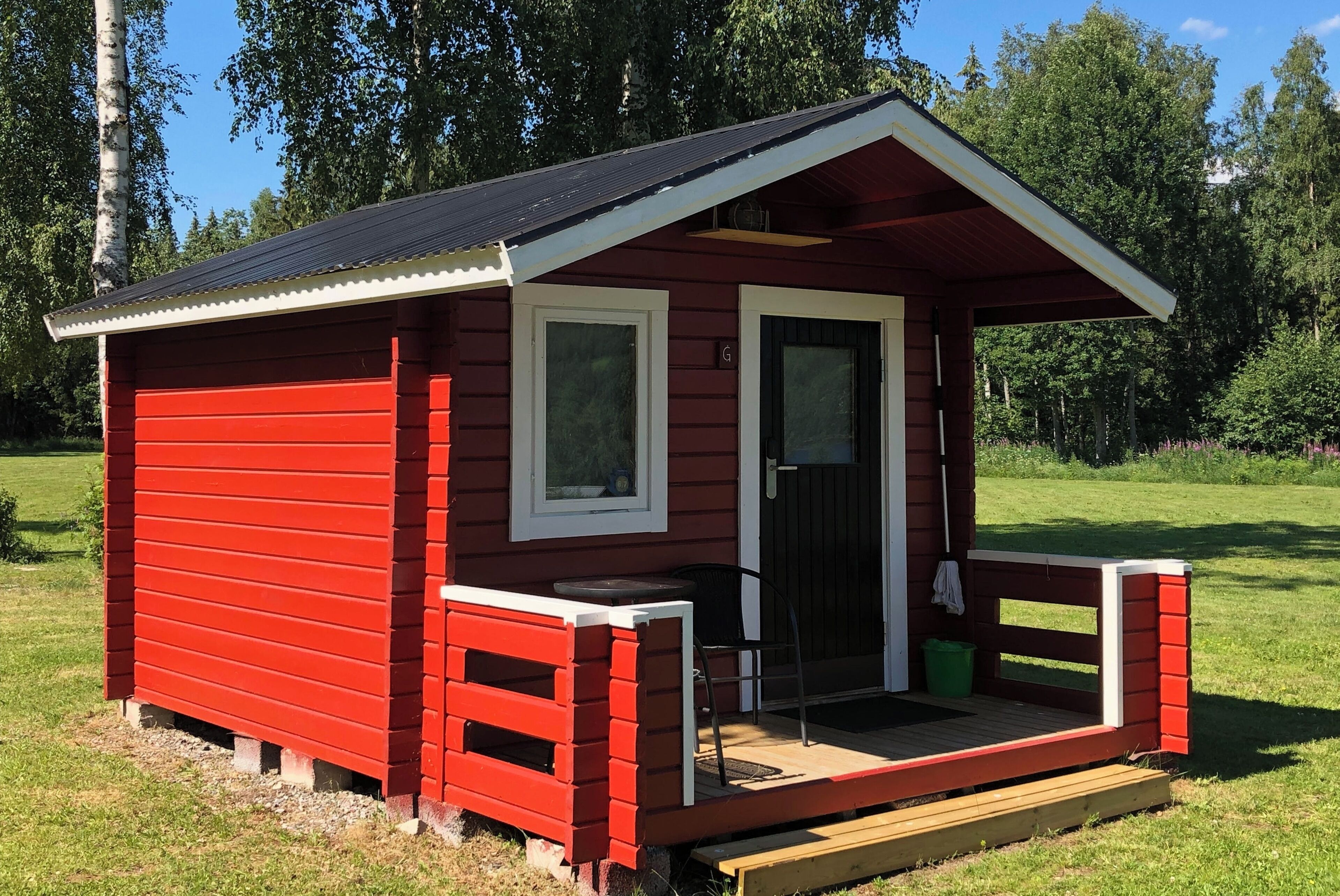 Småhus – standard, 2 enkeltsenger, delt bad, elveutsikt | Oppholdsområde | Peis og bøker