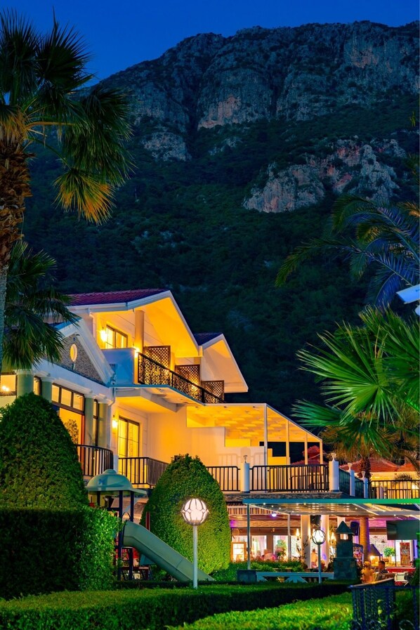 Vista frontal de la propiedad por la tarde o noche