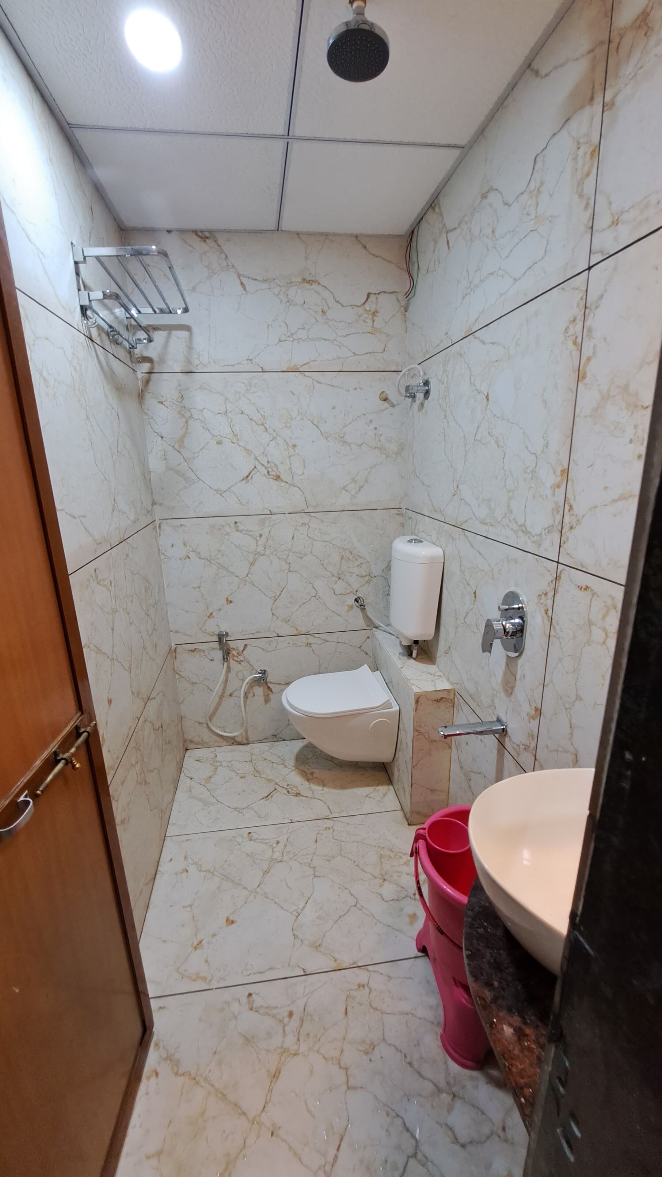 Un baño con inodoro, lavamanos, ducha y secador de manos.