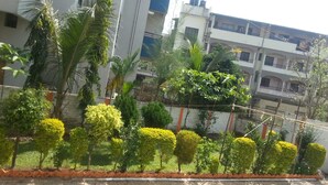 A landscaped area with neatly trimmed bushes and a paved walkway. - Hotel Dhruv Palace (Trimbak)