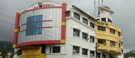 A multi-story building with a restaurant named "DHRUV PALACE RESTAURANT" on the ground floor.