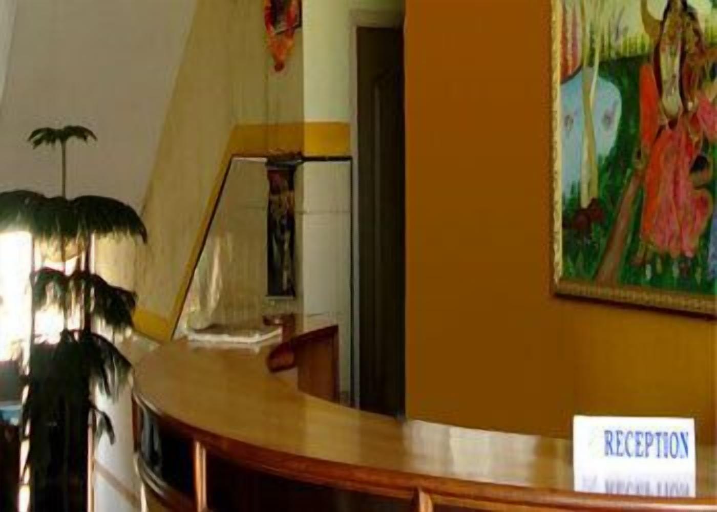 A reception desk with a sign labeled "RECEPTION" and a painting above it.