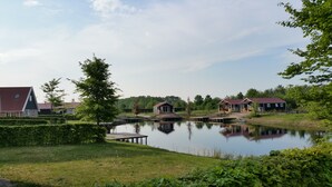 Järvenrantatontti, jossa on laituri, pieni puinen rakennus ja suuri punakattoinen talo.