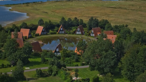 Maaseutualue, jossa on taloja, lampi ja järvi.