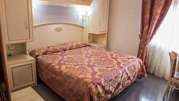 Une chambre à coucher comprenant un lit, des tables de chevet, une armoire et une chaise.