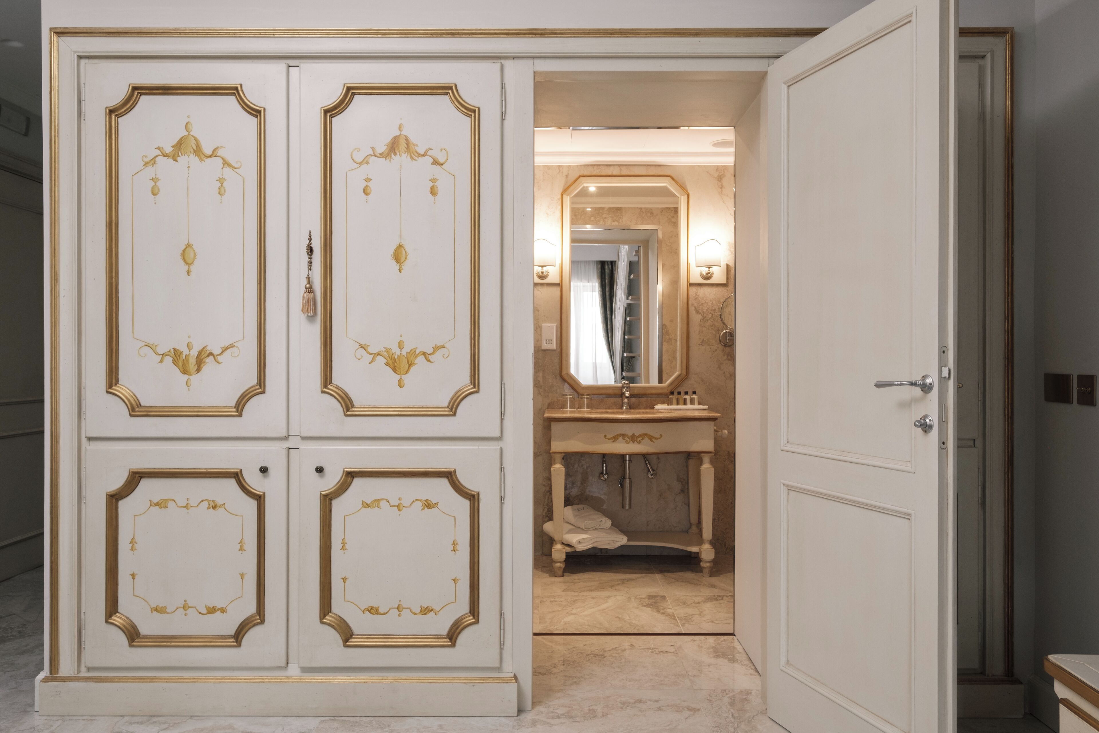 Un baño lujoso con un espejo grande, tocador y bañera.
