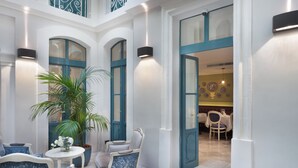 A spacious lobby with a seating area, a large potted plant, and a dining area visible through an open door. - Domus Zamittello (Valletta)