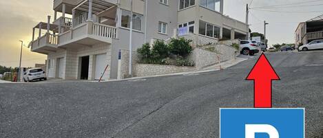 Ein mehrstöckiges Gebäude mit einem Parkschild, das einen Parkbereich kennzeichnet.