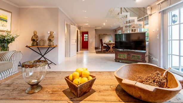 A modern living room with a wooden coffee table, a bowl of lemons, and decorative statues. - Ferienwohnung Rosen/horstweg 5 (Sylt)