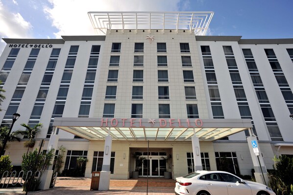 A multi-story hotel with a prominent entrance, large windows, and a clear sky.