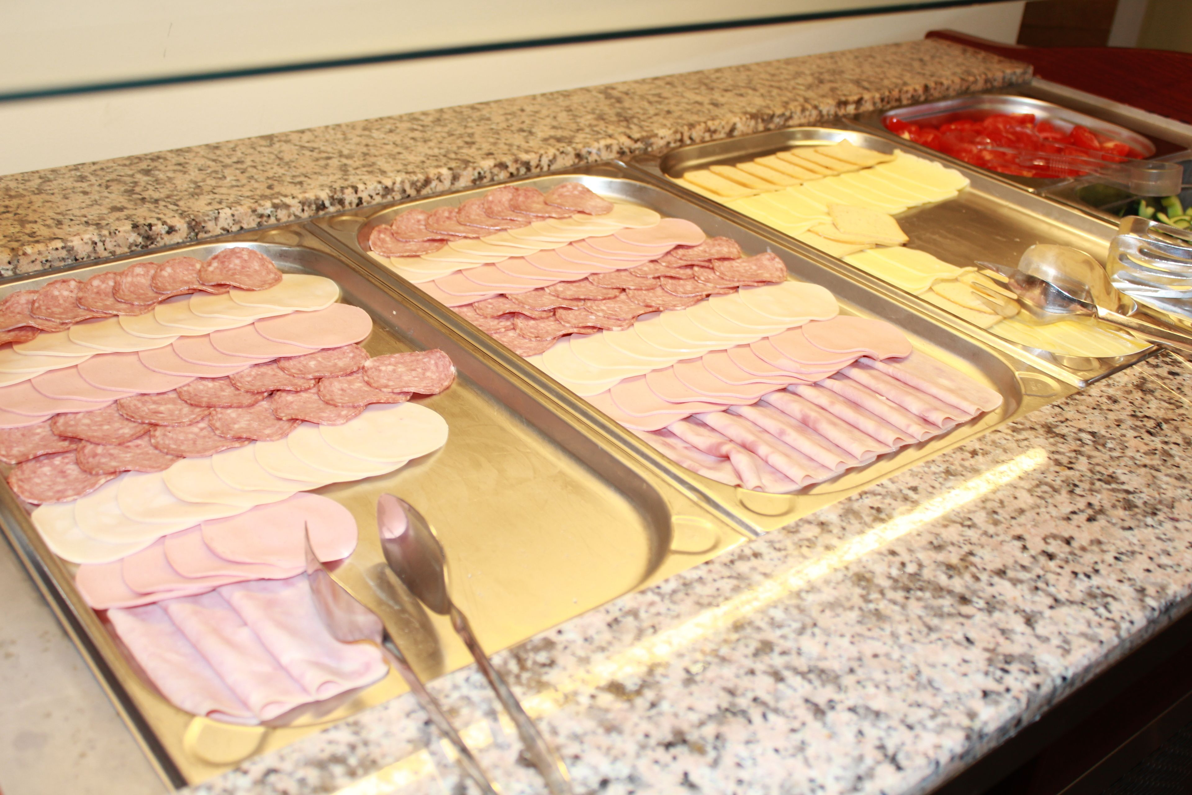 Un bufé con diferentes carnes y quesos.